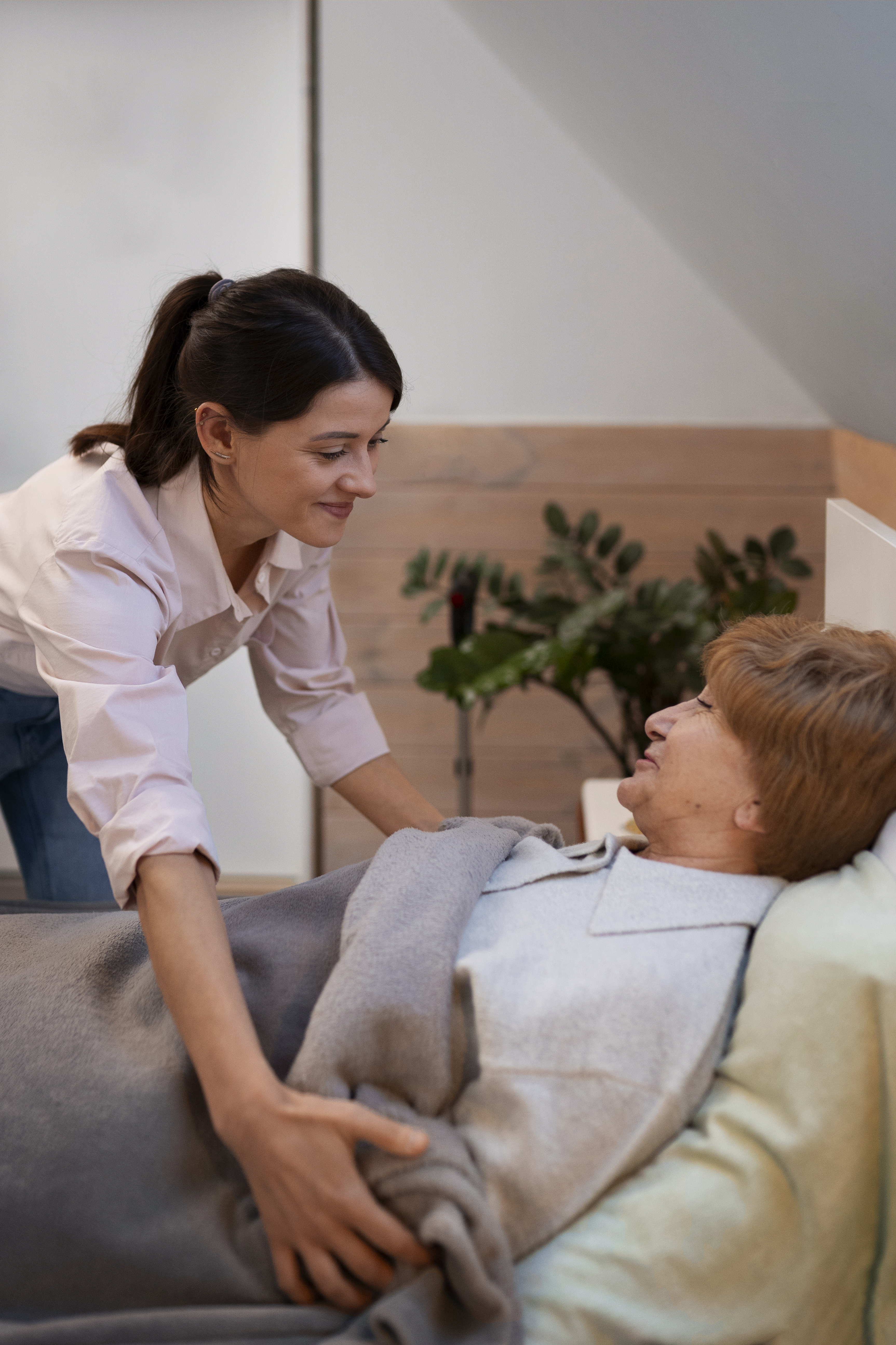Professional caregiver providing gentle assistance to an elderly woman at her Connecticut home