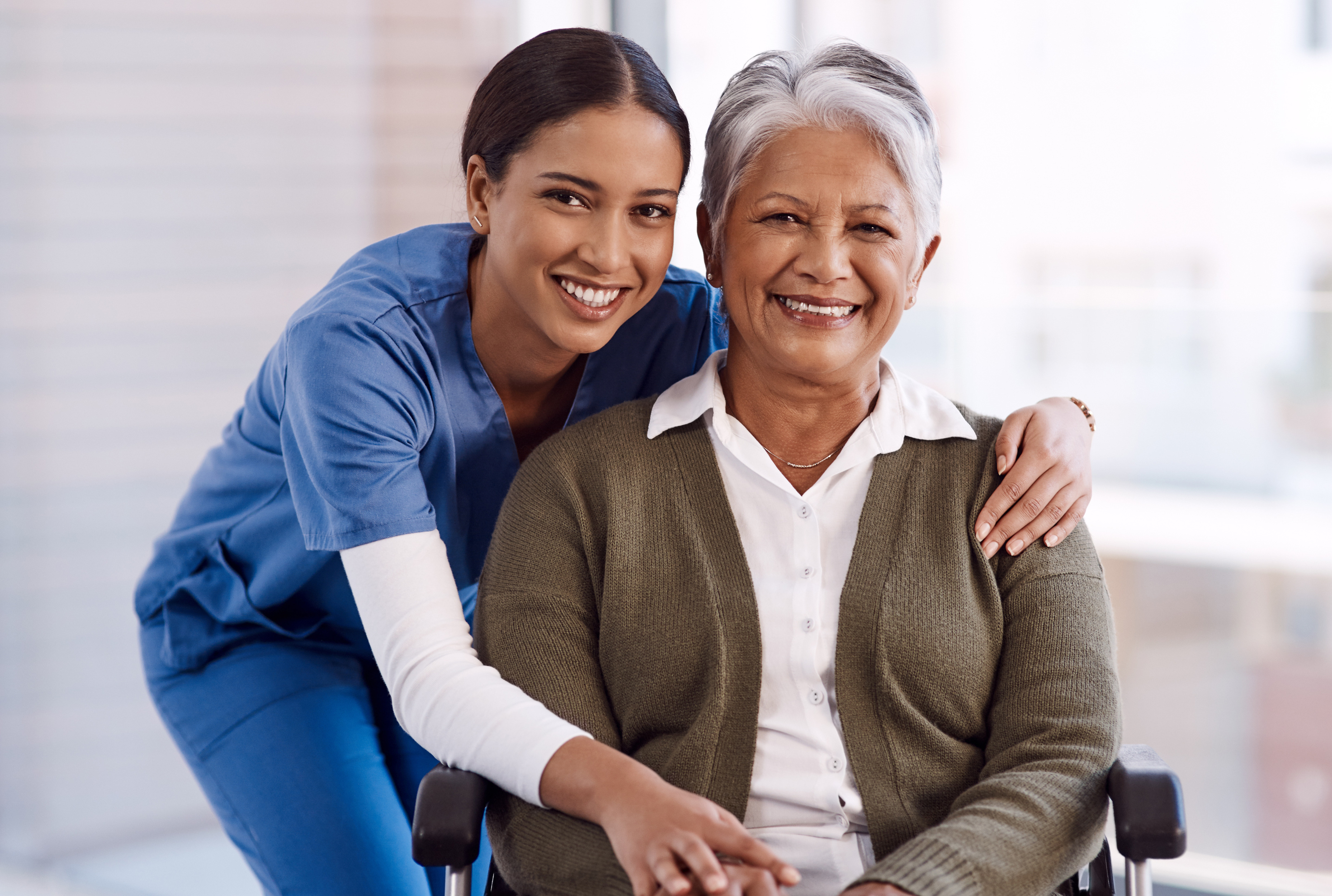 Nurse smiling with an elderly woman in a wheelchair, representing Greys Home Care's approachable and knowledgeable care team