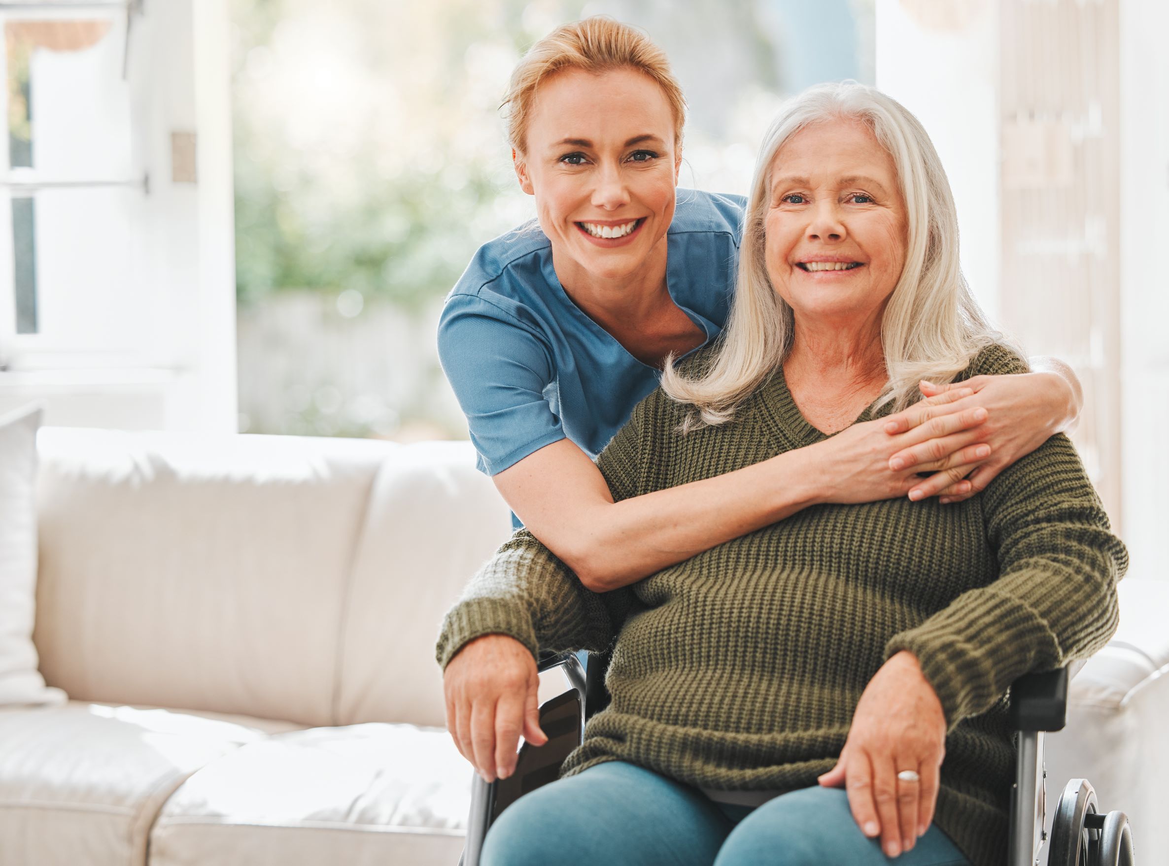 A warm hug between a Greys Home Care caregiver and her elderly client, capturing the bond of trust